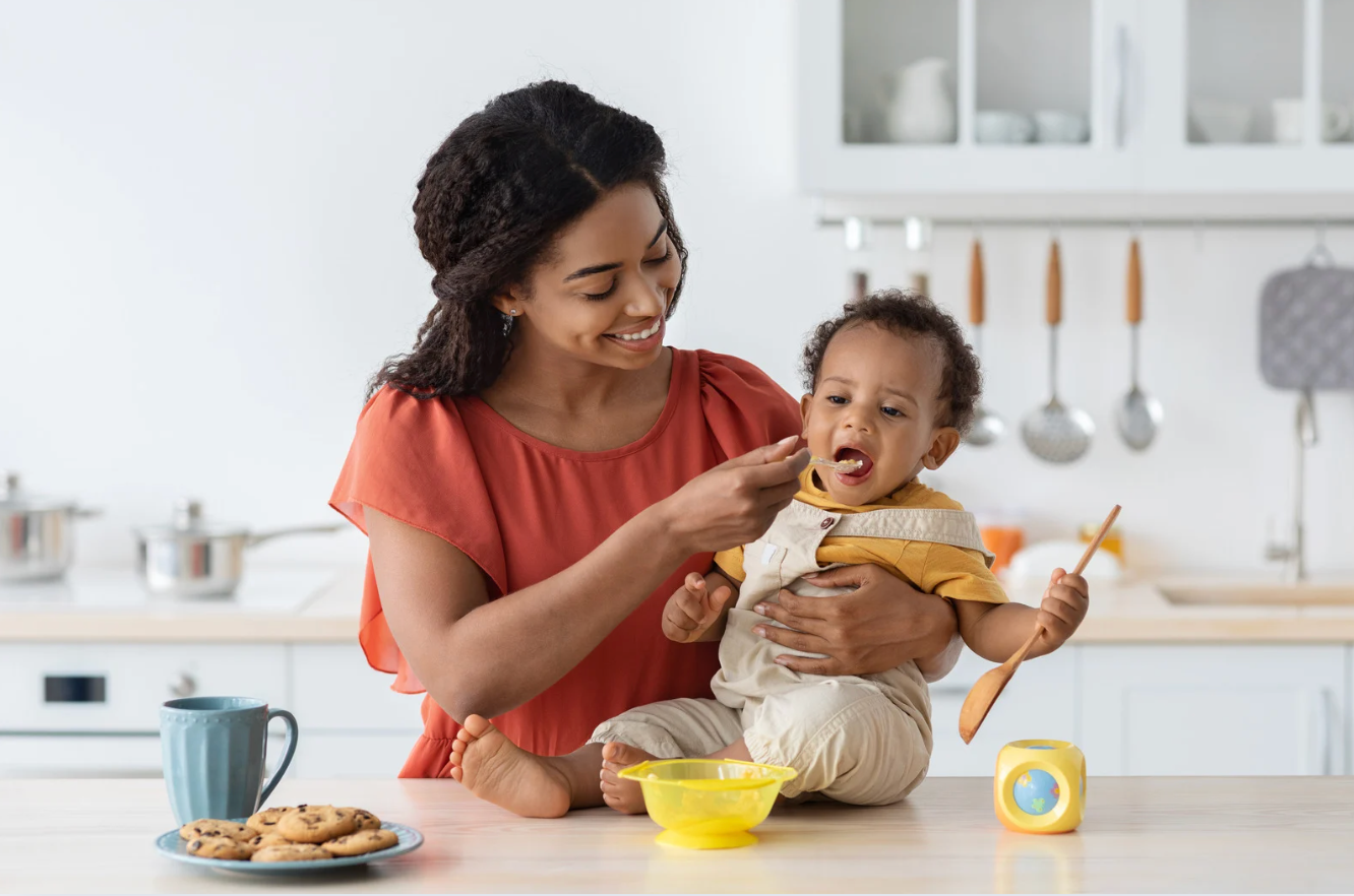 Mom feeding baby solids for the first time – baby-led weaning example