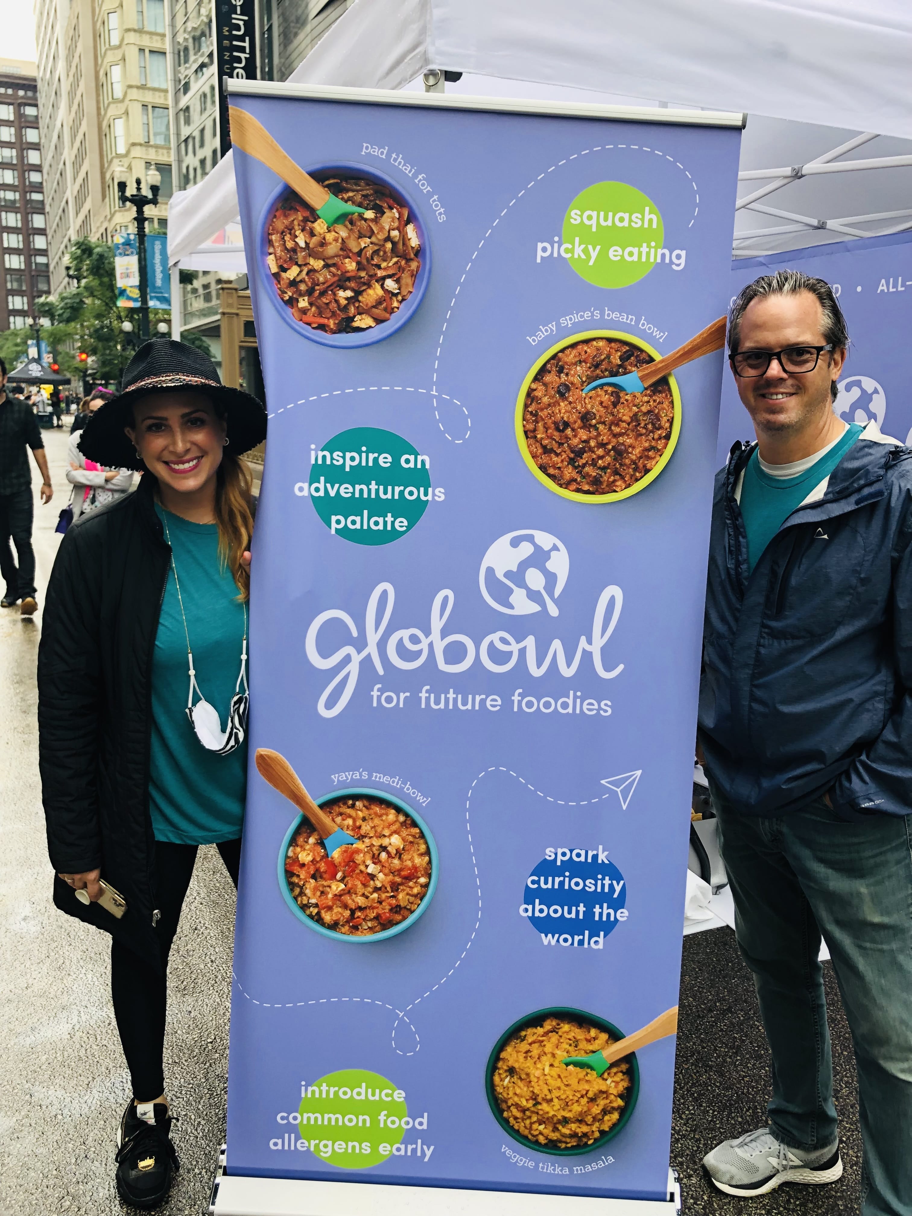 Founder Erica and husband Terry standing on either side of a Globowl brand banner